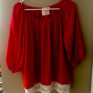Red women’s shirt with cream lace trim at the bottom size small